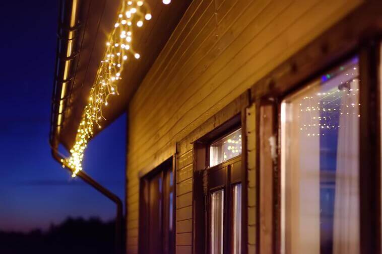 Holiday lights along the roof edge of a wooden building